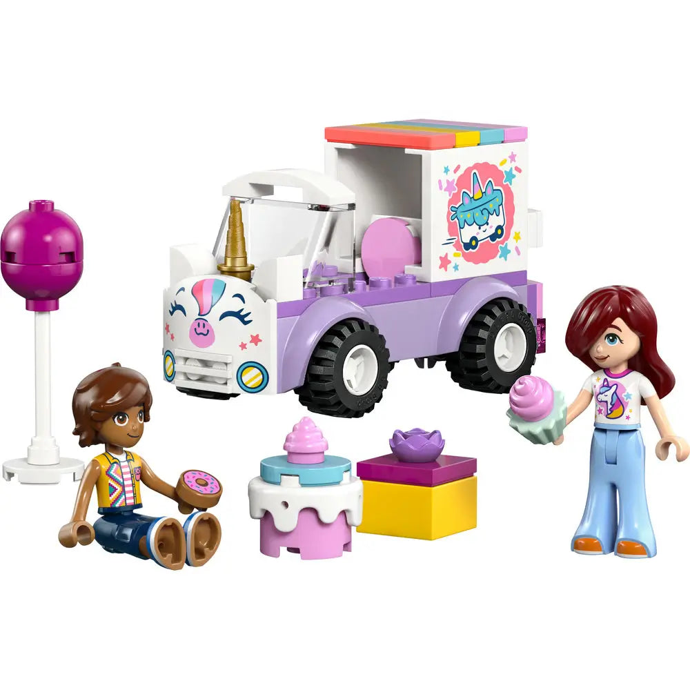 LEGO Friends Unicorn Cake Delivery Car toy features pastel purple, white, and pink plastic blocks forming a small delivery truck with unicorn face details, rolling wheels, cake accessories, and two mini-doll figures shown on a clean white background.