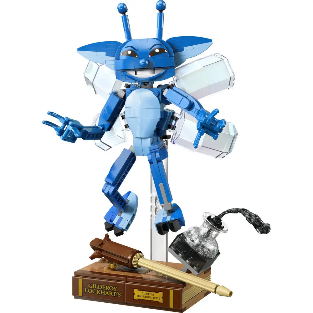LEGO Harry Potter Cornish Pixie display model built in bright blue bricks, shown hovering on a clear stand above a brown base with Gilderoy Lockhart’s book, wand, and inkwell accessories against a white background.