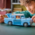 Child assembling LEGO Harry Potter Enchanted Flying Ford Anglia made of light blue plastic with opening doors and removable roof, holding pieces at hand scale to show interactive building and creative play indoors.