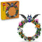 LEGO Halloween Wreath 40825 set pairs brown-and-yellow 617-piece packaging with the green brick wreath, featuring a bat, ghost, pumpkin, flowers, spiders, and webs.