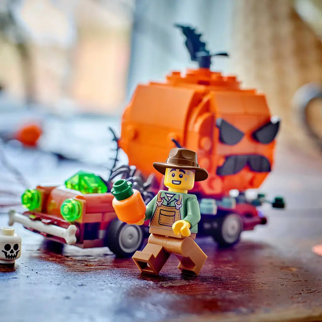 LEGO Jack-O'-Lantern Pickup Truck scene shows a brown brick vehicle with a large orange pumpkin, black spider, green lights, and farmer minifigure on a wooden tabletop.