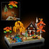 LEGO autumn cottage garden scene shows multicolored plastic trees, a small house, flowing stream, and garden details with layered textures, presented as a complete decorative display on a neutral studio background.