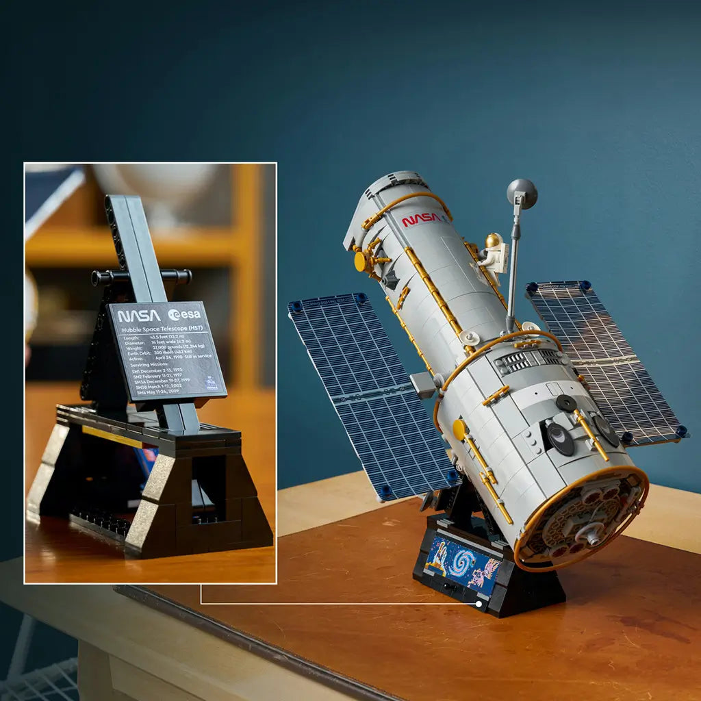 LEGO Icons Hubble Space Telescope display features a gray cylindrical brick-built telescope with gold trim and blue solar panels on a black stand, plus an information plaque.