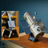 LEGO Icons Hubble Space Telescope display features a gray cylindrical brick-built telescope with gold trim and blue solar panels on a black stand, plus an information plaque.