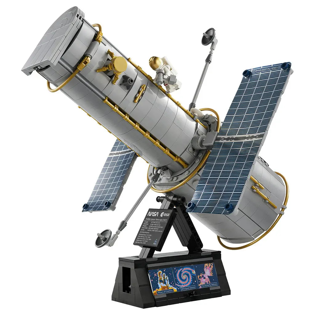 LEGO Icons Hubble Space Telescope model features a gray brick-built cylindrical body, gold piping, blue solar panels and astronaut figure mounted on a black display stand.