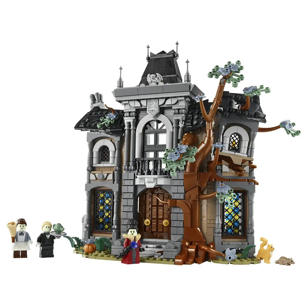 LEGO Icons Mayor Manor set 11383 features a gray and brown plastic gothic mansion with black roofs, stained-glass windows, a twisting tree, three minifigures and animals on white.
