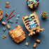 LEGO Ideas E.T. building set in tan and brown bricks is partly assembled on a dark tabletop, revealing colorful interior pieces beside blue eyes and a flowerpot.