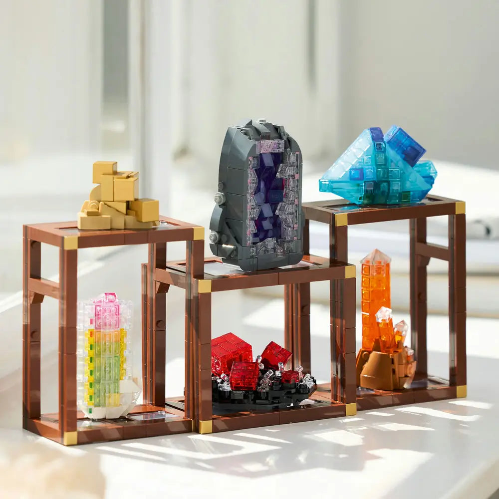 Completed LEGO Ideas Mineral Collection displayed on a white shelf, showcasing blue, purple, red, orange, and gold crystal models in modular brown display frames.