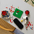 LEGO Ideas Snoopy's Doghouse parts in red, white, green and black bricks surround a partly built base, Snoopy figure and yellow Woodstock on a gray tabletop.