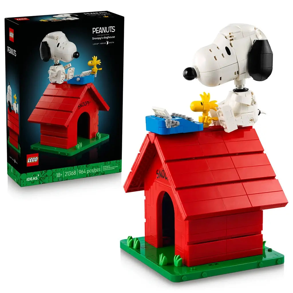 LEGO Ideas Snoopy's Doghouse set 21368 pairs its black box with a red brick doghouse, white Snoopy, yellow Woodstock and blue typewriter on a green base against white.