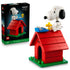 LEGO Ideas Snoopy's Doghouse set 21368 pairs its black box with a red brick doghouse, white Snoopy, yellow Woodstock and blue typewriter on a green base against white.