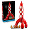 LEGO Ideas Tintin Moon Rocket building kit includes a red and white plastic rocket with rounded fins, astronaut minifigures and retail packaging, arranged on a white background.
