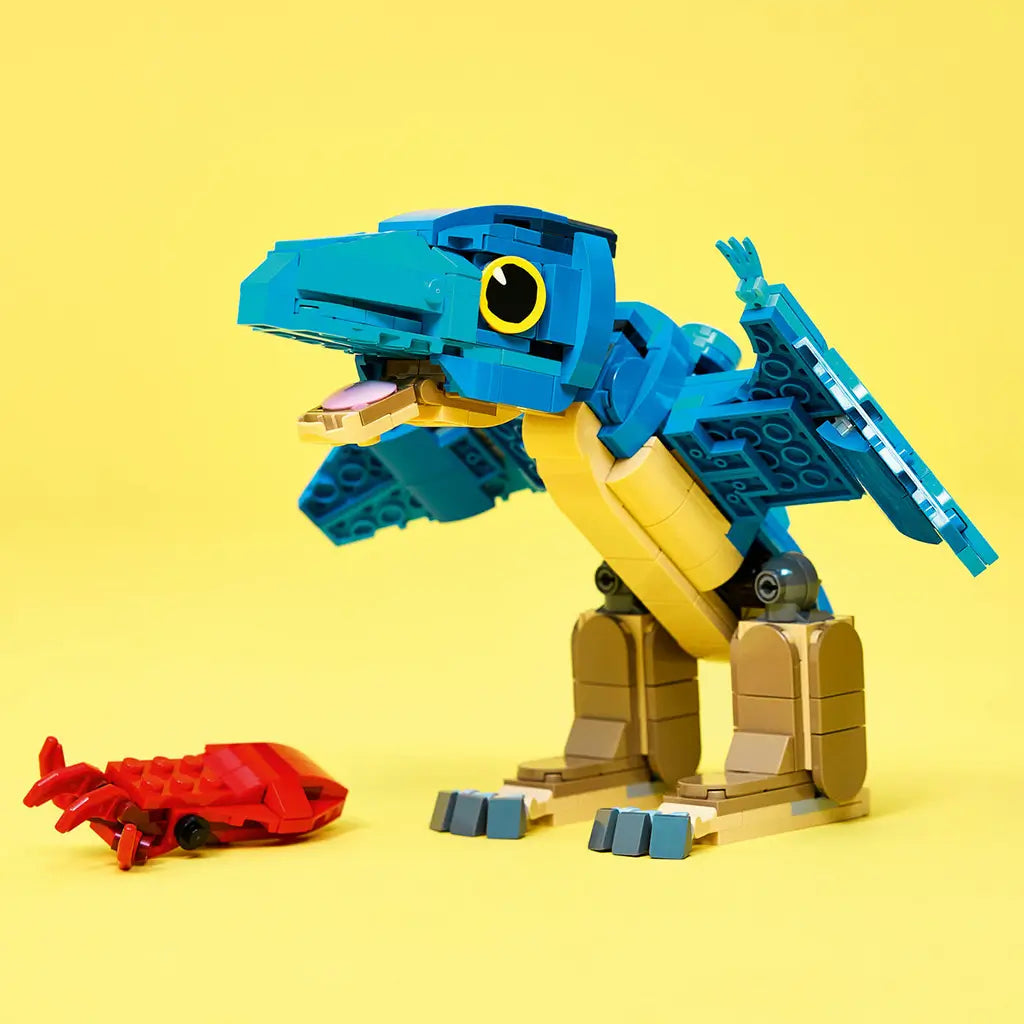 LEGO Jurassic World Baby Dinosaur Pteranodon model features a blue plastic brick-built flying dinosaur with tan legs and a red seafood piece displayed on a yellow background.