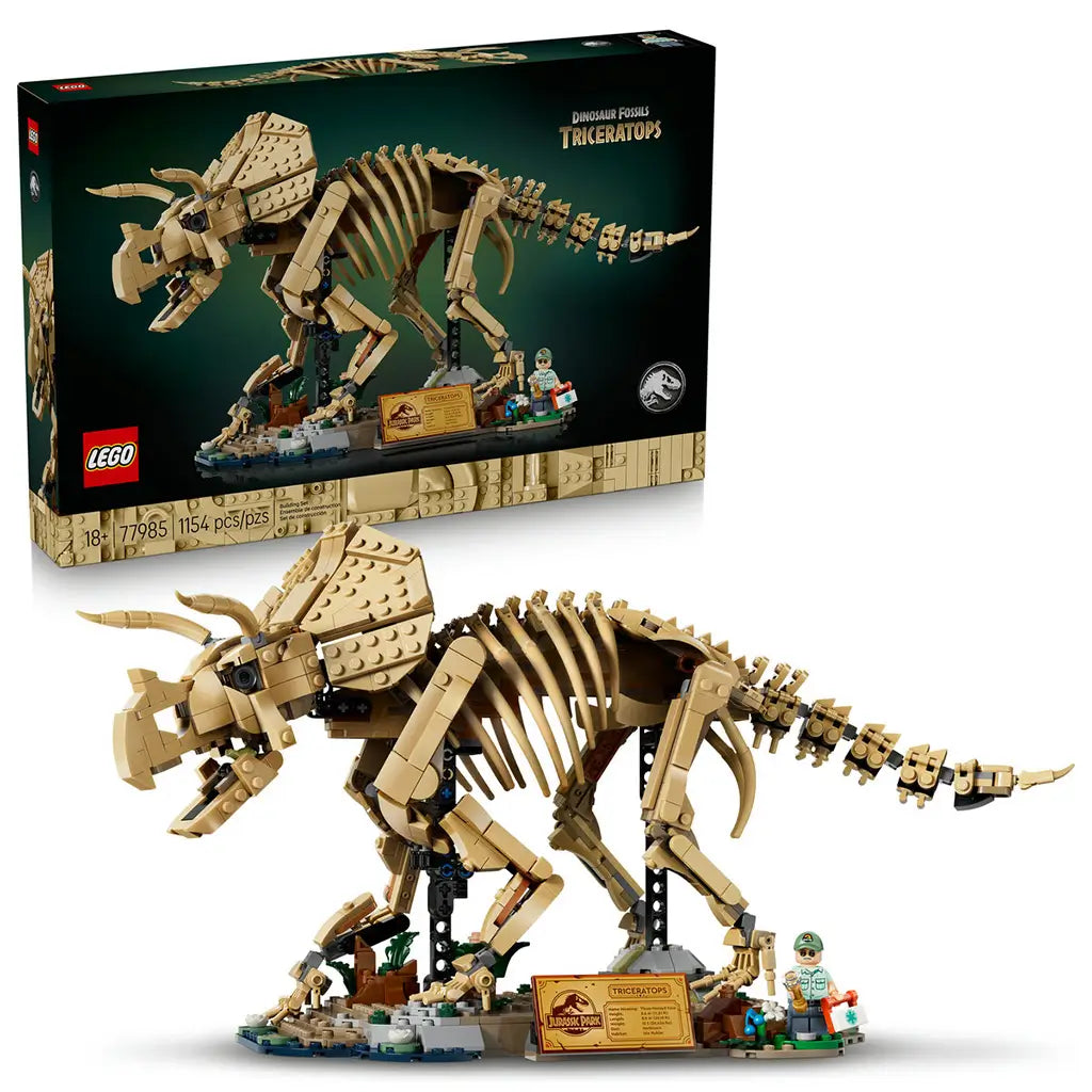 LEGO Jurassic World Triceratops 77985 set pairs a tan brick-built fossil skeleton and display base with its black retail box, plaque and minifigure against white.