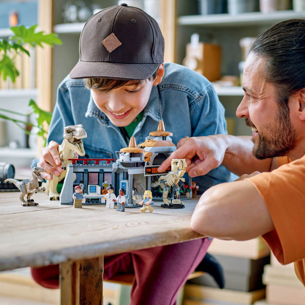 Father and son playing with the LEGO® Jurassic World Visitor Center: T-Rex & Raptor Attack 693 Piece Building Set
