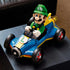 LEGO Mario Kart Luigi & Mach 8 display features bright green, blue and yellow plastic surfaces, a streamlined kart shape with oversized wheels, presented on a dark tabletop in a living room setting.