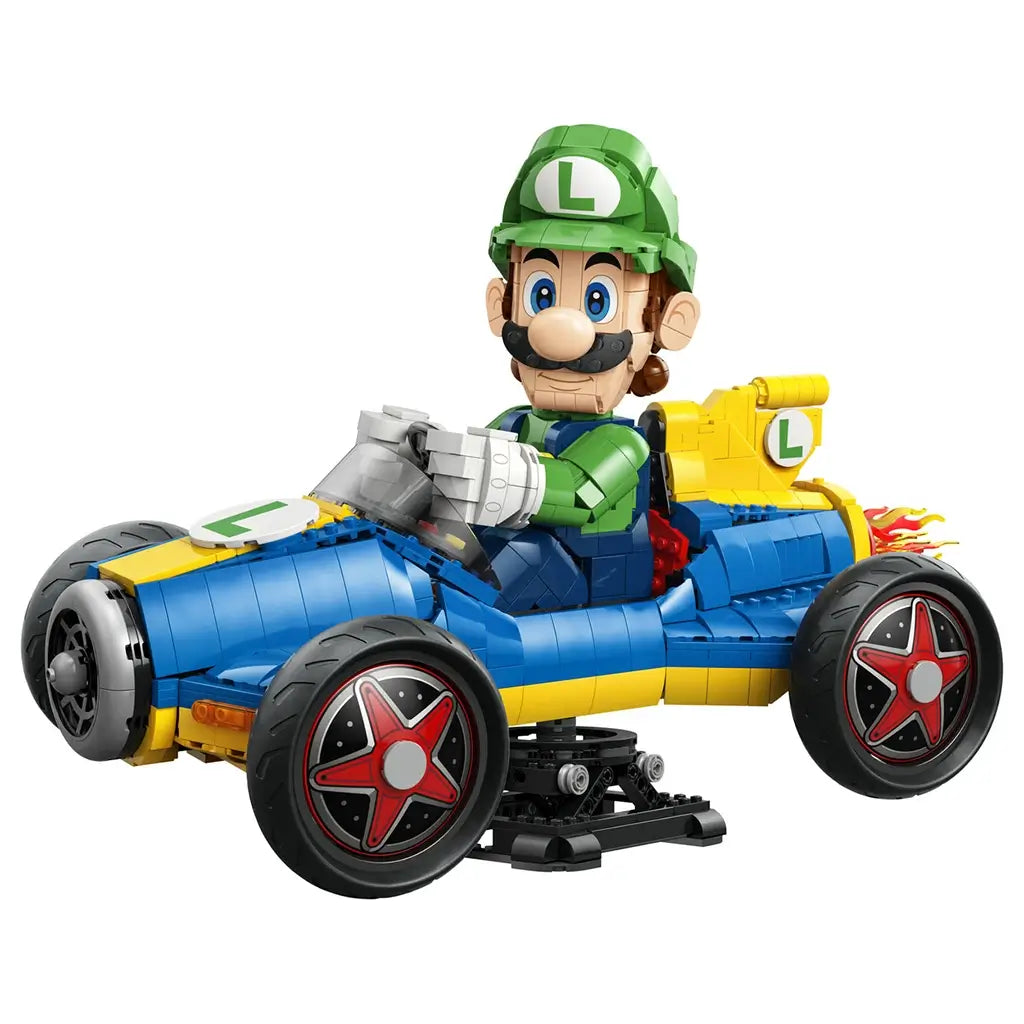 LEGO Mario Kart Luigi & Mach 8 model features green, blue and yellow plastic construction, a detailed driver figure in a racing kart with large wheels, displayed on a stand against a studio backdrop.