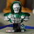 LEGO Marvel Doctor Doom Bust display model has a dark green hood, silver mask, gray armor and chain on a black base, with matching minifigure beside it in a home setting.