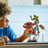 LEGO Marvel lifestyle builder scene shows a child holding the assembled Hulkbuster and Hulk figures, highlighting articulated joints, battle accessories, and the themed display base during hands-on play.