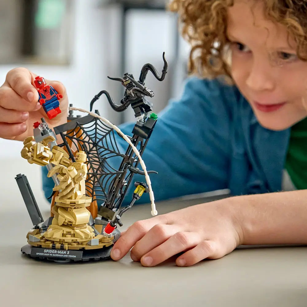 LEGO Marvel Spider-Man 3 play scene showing a child interacting with the assembled Sandman and Venom display, highlighting scale, web accessories, and hands-on imaginative play in a home setting.