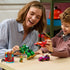 LEGO Marvel Loki vs. Team Iron Man playset in colorful plastic is used by an adult and child, who hold the green Iron Hulk mech and red jet beside the car and Loki.