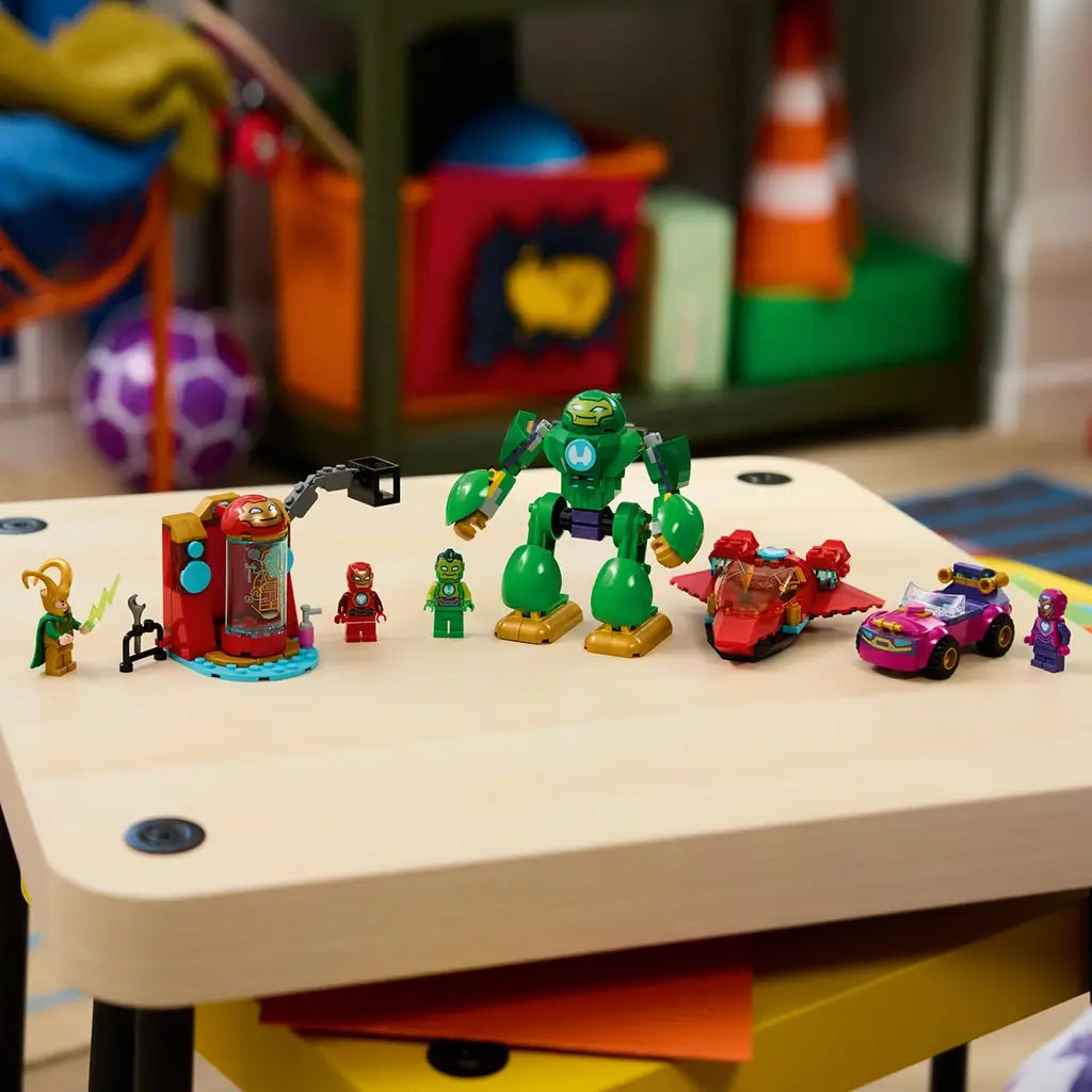 LEGO Marvel Loki vs. Team Iron Man set in colorful plastic is lined up on a table with Loki, lab station, figures, green Iron Hulk mech, red jet, and purple car.