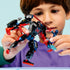 LEGO Marvel Spider-Man mech action figure held by a child, featuring black and red articulated armor, clawed hands, and web accessories, emphasizing imaginative play and scale against a soft blue background.