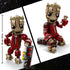 LEGO Marvel Ravager Jumpsuit Groot size comparison shows tan and light brown wood-textured bricks forming a smiling Groot character in a dark red Ravager jumpsuit, displayed beside a height marker indicating approximately 25 centimeters or 10 inches tall on a clean studio background.