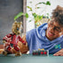 LEGO Marvel Groot lifestyle builder image shows a smiling child holding the completed Groot figure, highlighting articulated joints, expressive facial design, and the red Ravager jumpsuit during hands-on play.