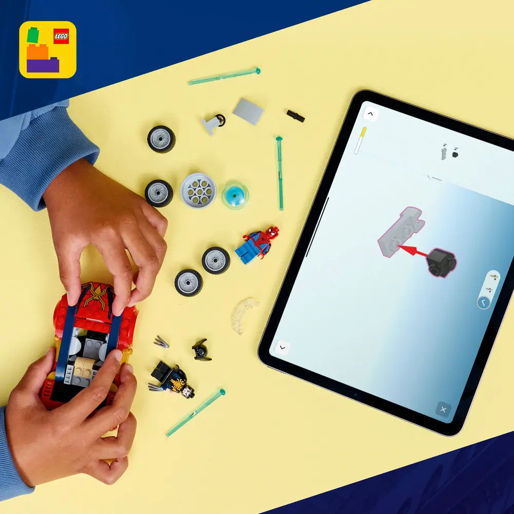 LEGO Marvel Spider-Man building set shown from above, with red and blue car pieces, wheels, minifigures, and accessories arranged on a yellow surface beside a tablet showing digital building instructions.