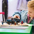 LEGO Marvel Spider-Man playset, blue plastic armored prison truck with rugged body panels and action features, displayed with minifigures as a child recreates superhero chase scenes indoors.