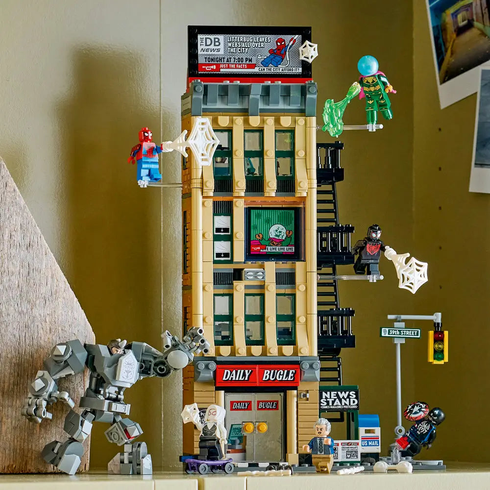 LEGO Marvel Daily Bugle display shows the fully built tan newspaper tower with black fire escapes, street accessories, and Spider-Man characters staged in dynamic action poses.