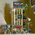LEGO Marvel Daily Bugle display shows the fully built tan newspaper tower with black fire escapes, street accessories, and Spider-Man characters staged in dynamic action poses.