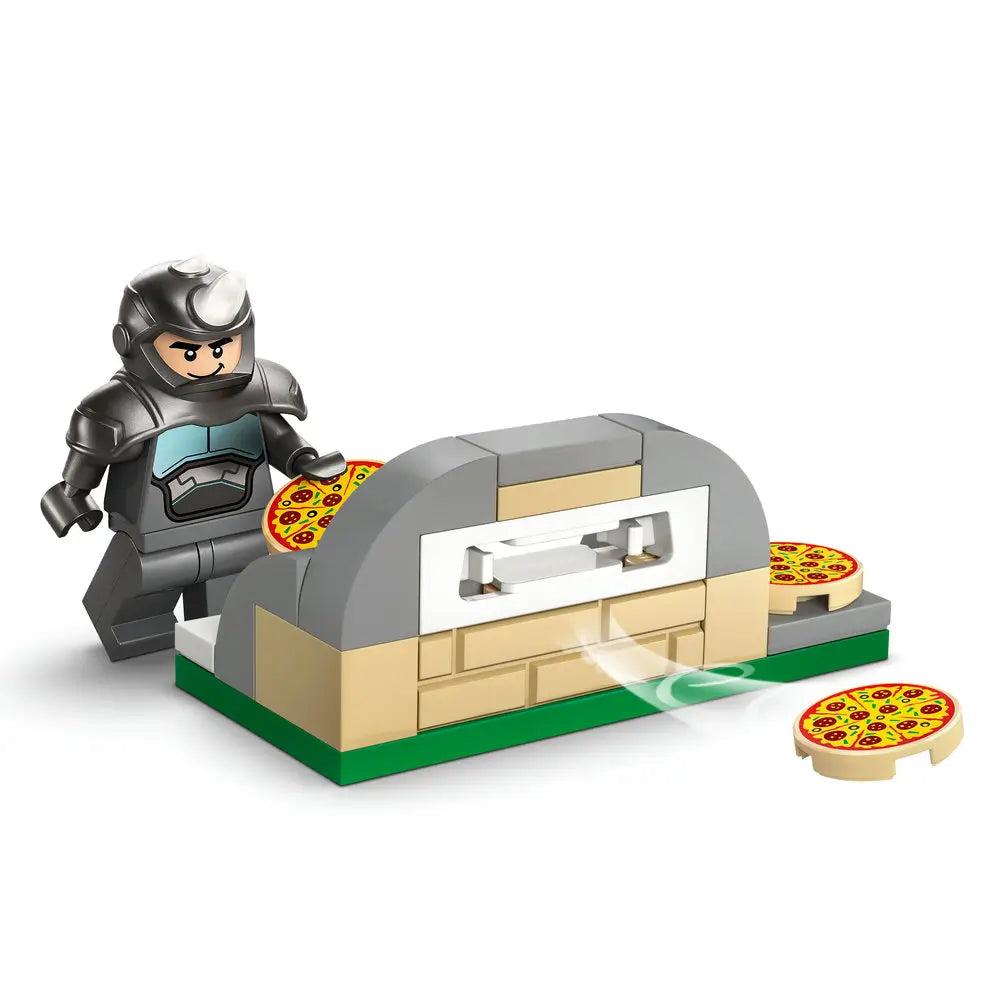 LEGO Marvel Rhino minifigure in dark gray plastic armor holding a pizza beside a tan and gray brick-built pizza oven with round tiles, displayed as a simple playset scene on a clean white background.