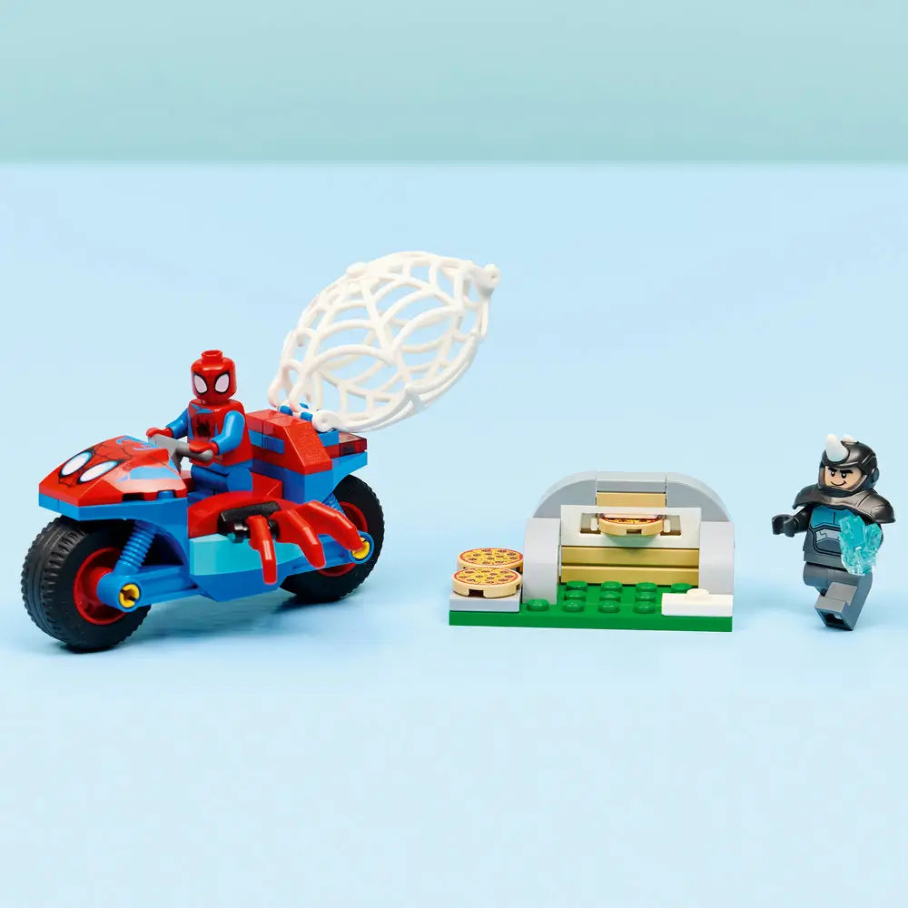 LEGO Marvel Spidey motorcycle and pizza oven display built from red, blue, tan, and gray bricks, featuring Spider-Man and Rhino minifigures posed on a light blue background for finished model showcase.