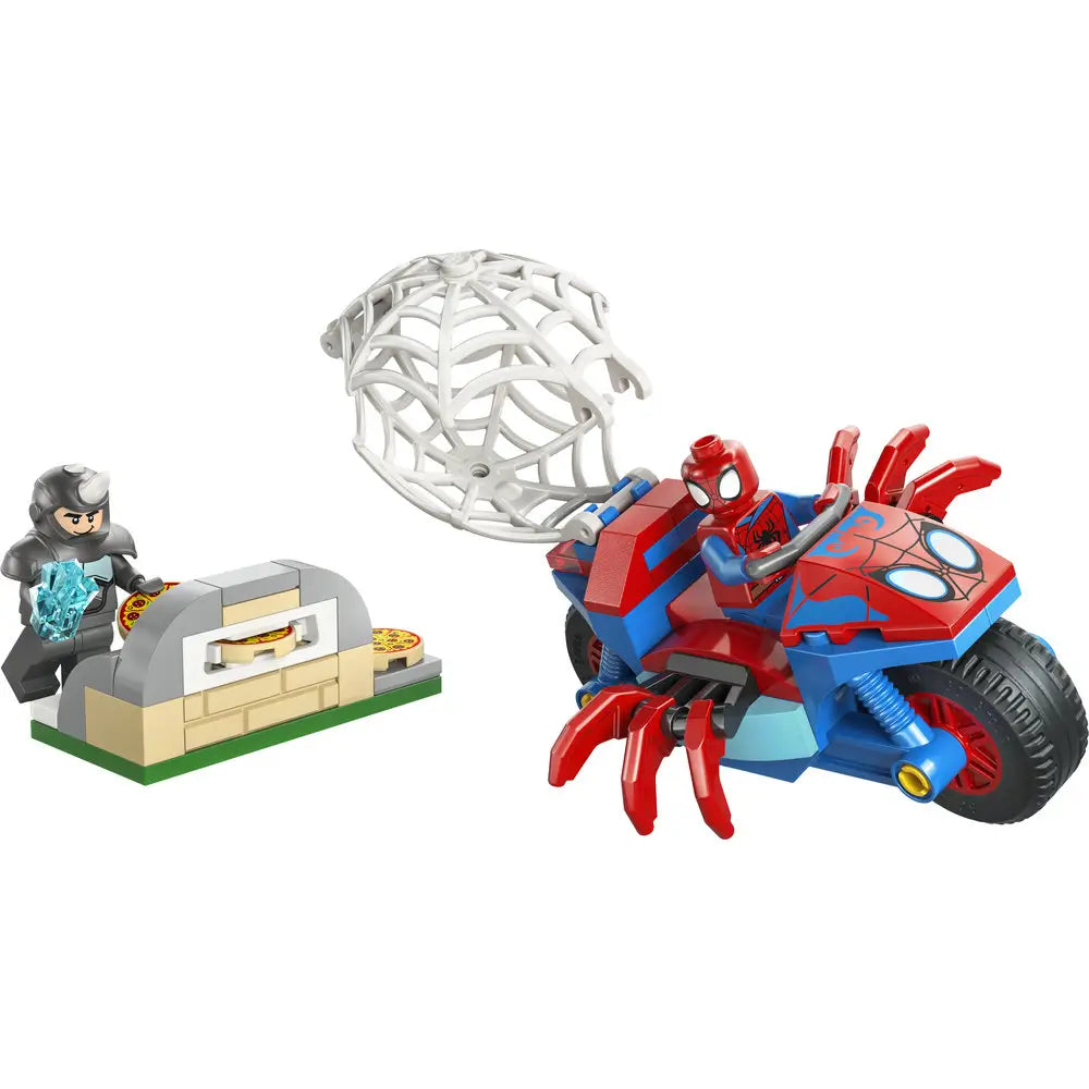 LEGO Marvel Spidey motorcycle toy in red and blue plastic with chunky spider-shaped body, web launcher, and rolling wheels, showing Spider-Man chasing Rhino near a small pizza oven build on a white background.