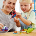 LEGO Marvel Spidey underwater vehicles lifestyle image shows an adult and child assembling and playing with colorful plastic submarines together, demonstrating shared building, creativity, and imaginative storytelling at home.