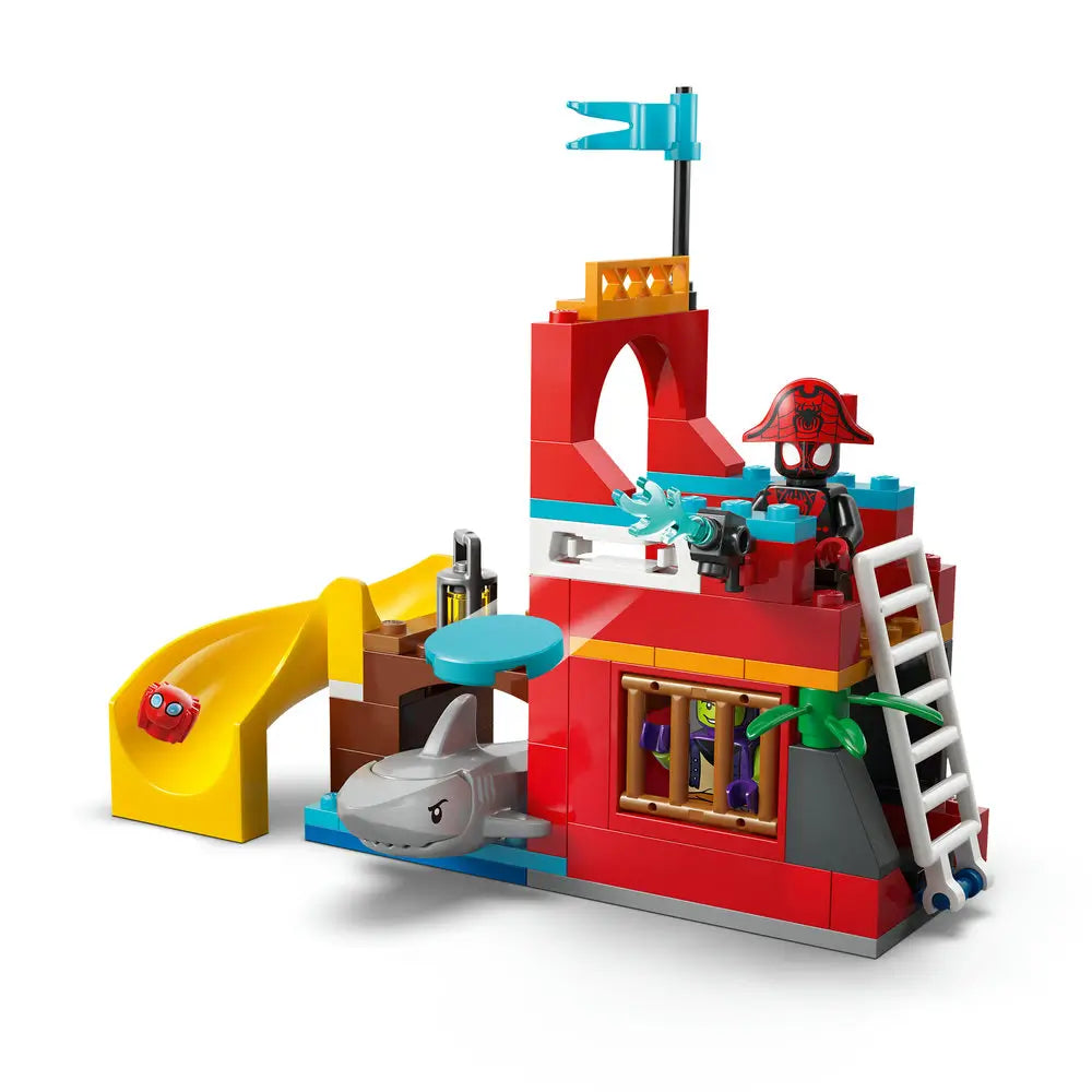 LEGO Marvel Spidey pirate hideout shows colorful plastic bricks forming a small dock tower with slide, ladder, shark, and character figures, presented as a compact action play scene on a clean white studio background.