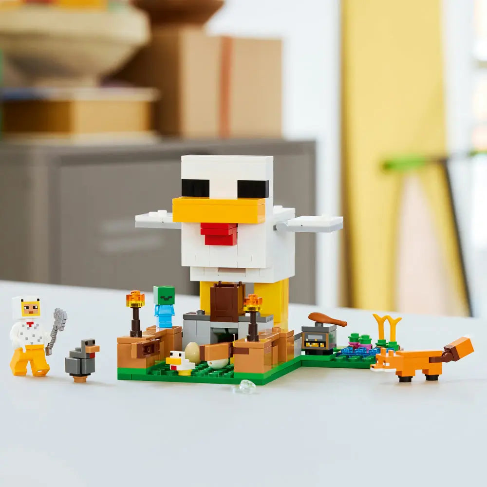 LEGO Minecraft Chicken Farm display showing completed white plastic chicken build with yellow legs, cubic block design for play and display, set on a green baseplate with animals and farm details.