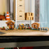LEGO Minecraft Evoker Village Attack in brown, tan and green bricks displays village houses, a farm, pavilion, iron golem, villagers and hostile mobs across a tabletop.