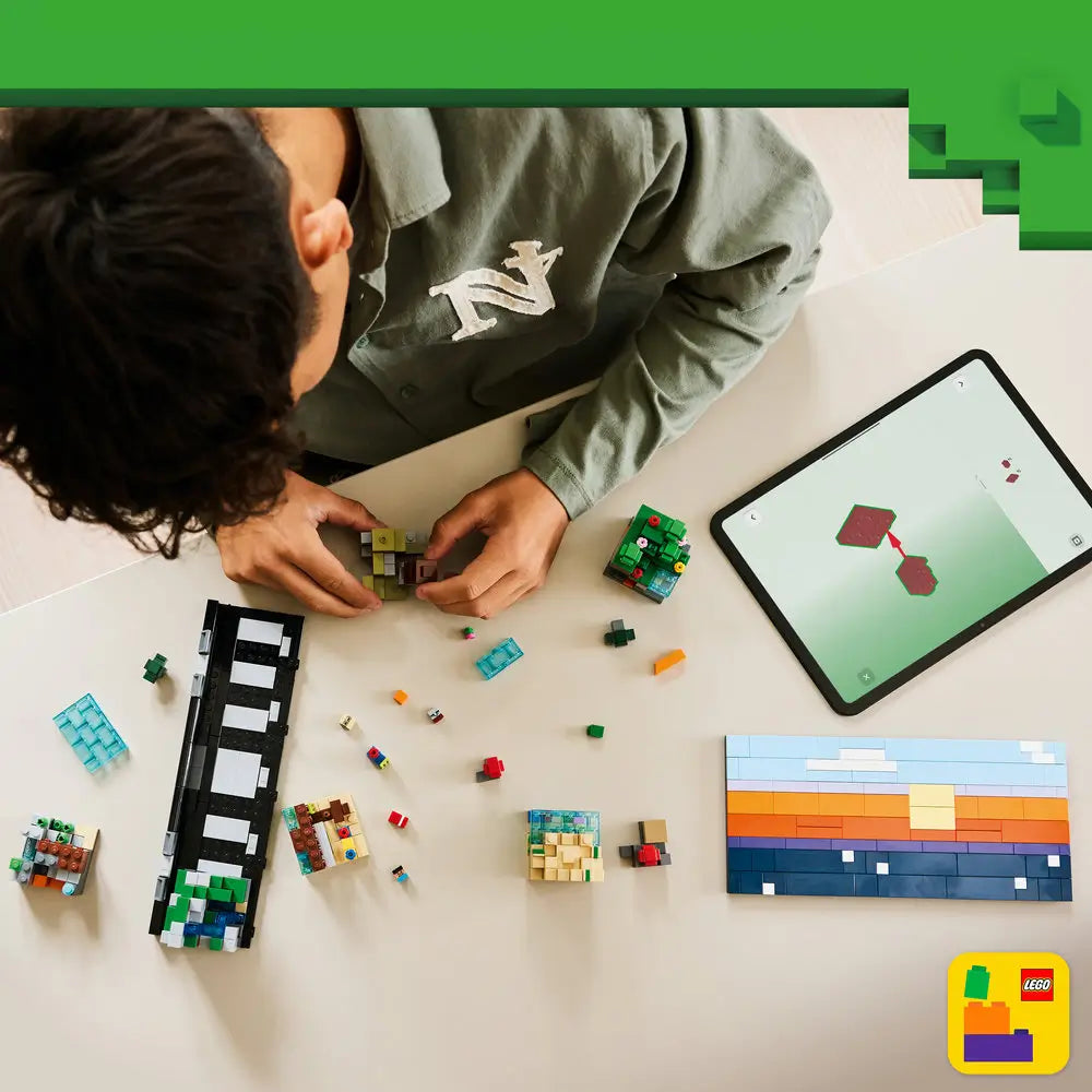 LEGO Minecraft building activity shows colorful plastic bricks, small biome sections, and modular pieces spread on a table as a builder assembles a rectangular landscape using guided digital instructions.