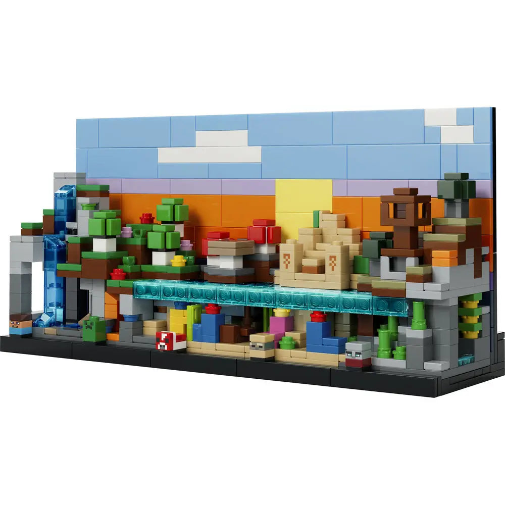 LEGO Minecraft Mini Biomes display features multicolored plastic bricks forming a layered rectangular scene with green trees, tan sand, blue water, and terrain sections set against a stylized sky background.