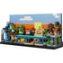 LEGO Minecraft Mini Biomes display features multicolored plastic bricks forming a layered rectangular scene with green trees, tan sand, blue water, and terrain sections set against a stylized sky background.