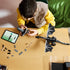 LEGO Minecraft The Ender Dragon build in black and gray bricks is assembled by a child at a table with loose pieces and digital instructions beside the winged model.