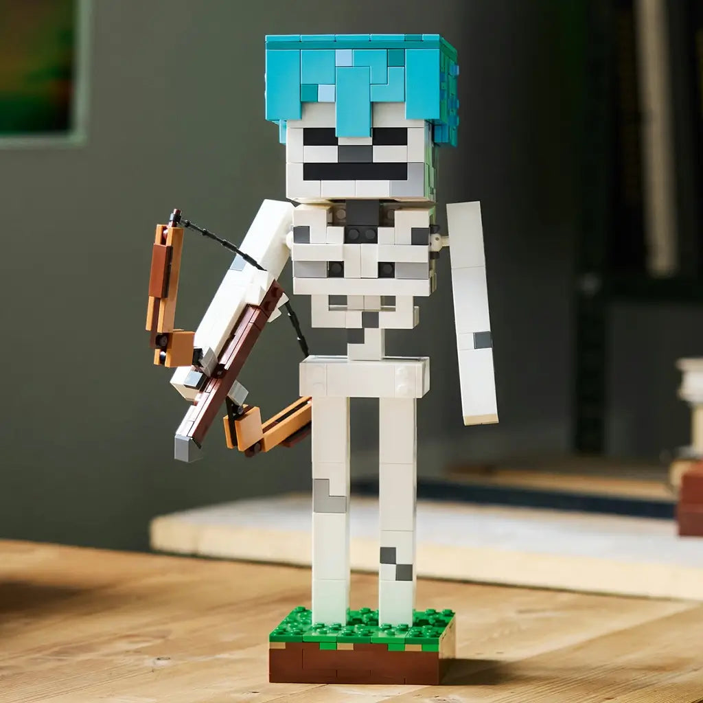LEGO Minecraft The Skeleton model in white and gray bricks stands on a brown and green base, wearing a turquoise helmet and holding a large articulated brown bow.
