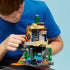 LEGO Minecraft Zombie Dungeon building scene shows a young builder holding the assembled desert ruin while positioning an explorer figure on the upper platform above zombie characters inside the cave opening.