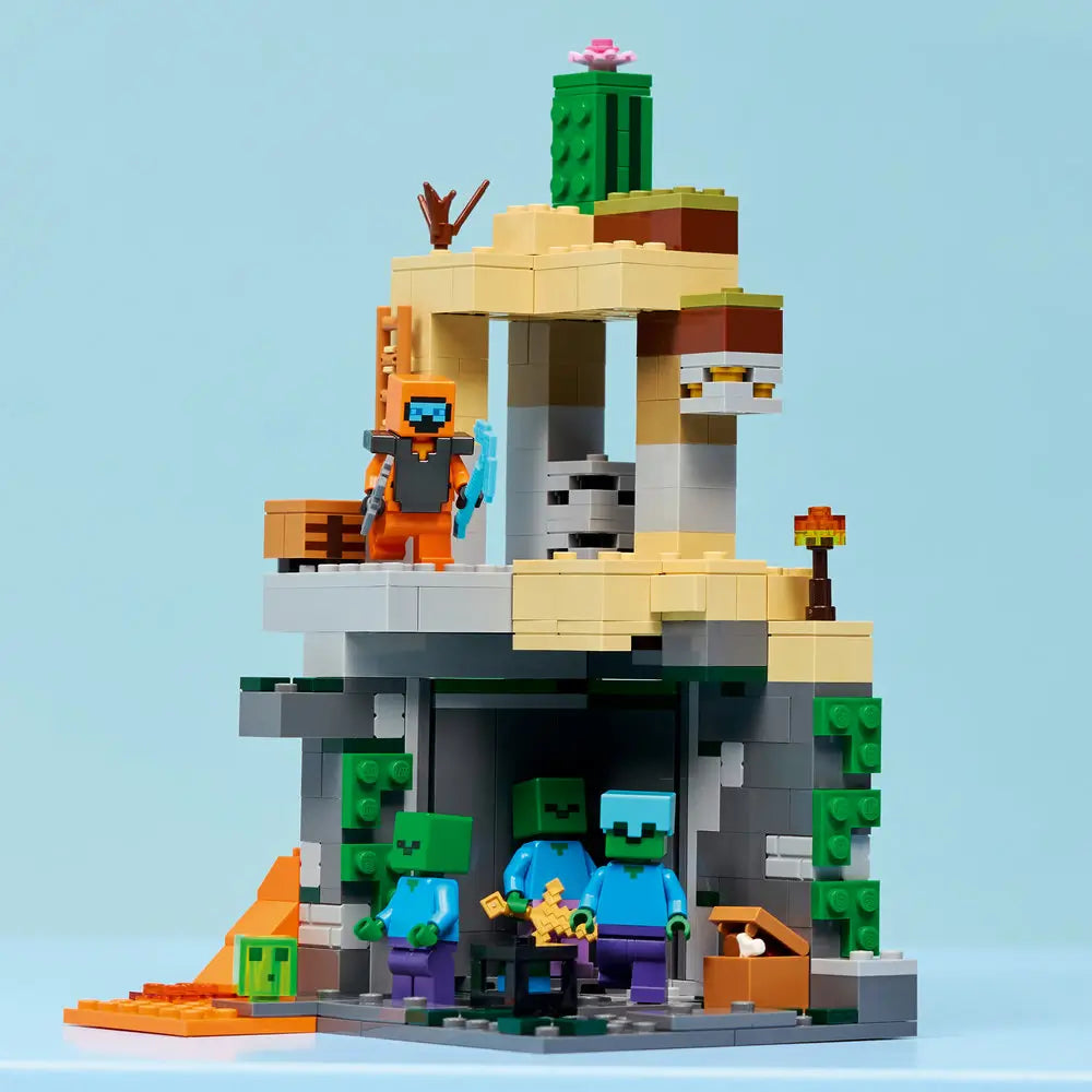LEGO Minecraft Zombie Dungeon completed display shows a tall desert-style ruin built from tan, gray, and green bricks, featuring lava, cactus details, and zombie figures positioned beneath an upper platform.