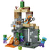 LEGO Minecraft Zombie Dungeon build features tan, gray, and green plastic bricks forming a vertical desert ruin with stacked stone platforms, ladders, cactus, lava elements, and multiple zombie figures in dynamic play poses.