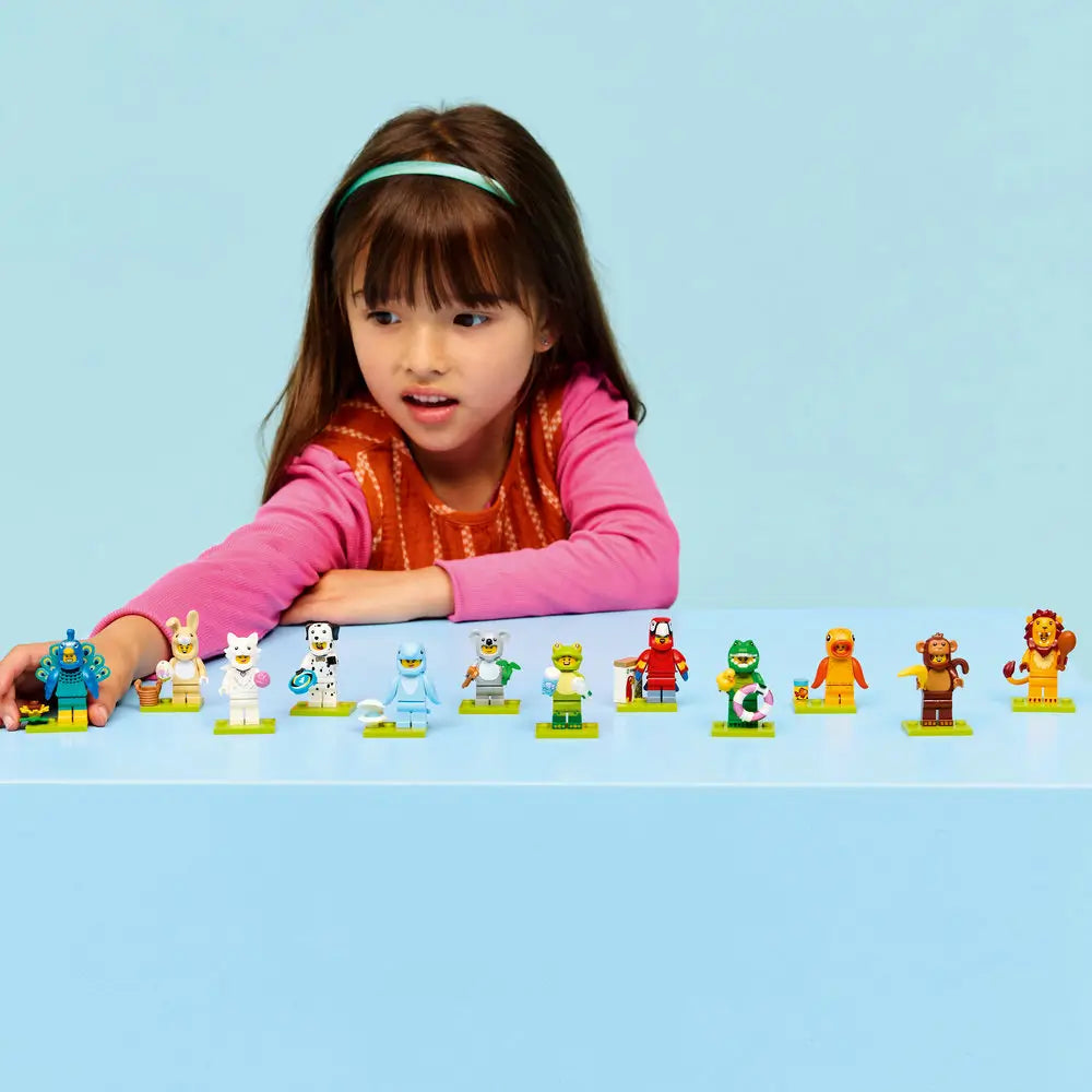 LEGO Minifigures Series 28 lifestyle builder image shows a child smiling and lining up completed animal costume minifigures on green base plates against a light blue background.
