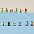 LEGO Minifigures Series 29 characters line pastel blue display blocks with colorful plastic fantasy, sports, and costume figures arranged against a soft beige background.